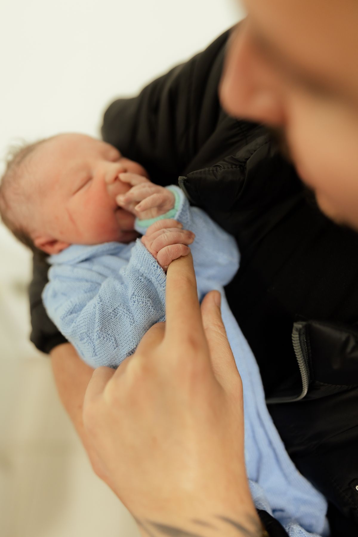 Tender moment of a newborn gently holding a parent's finger. Heartwarming and intimate family scene.