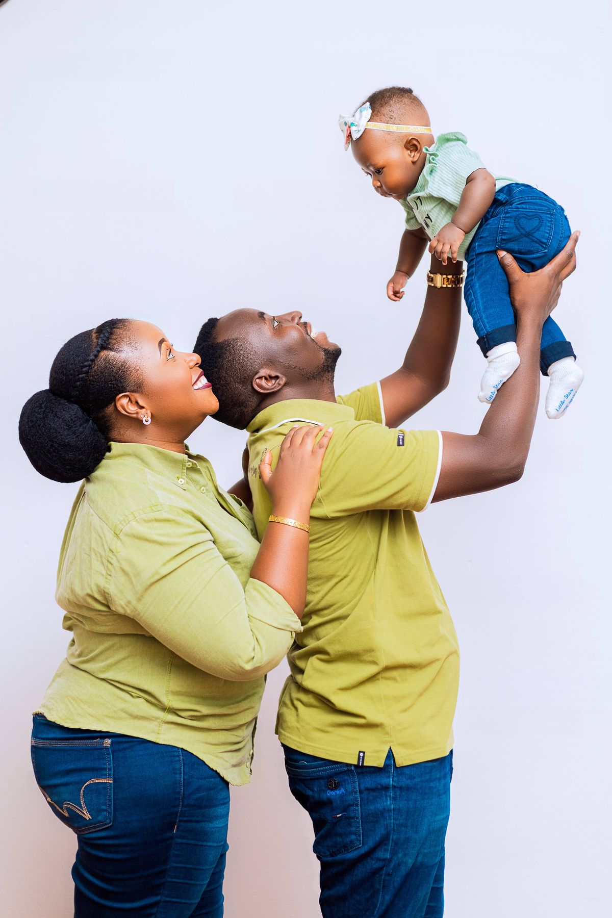 Happy parents lovingly lifting their smiling baby, showcasing family bond and joy.